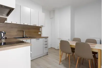a kitchen with a table with chairs and a sink at Apartment with 2 bedrooms with kitchen near metro in Prague