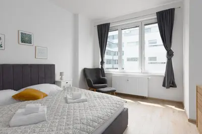 a bedroom with a bed and a chair and a window at Apartment with 2 bedrooms with kitchen near metro in Prague