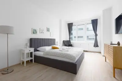 a white bedroom with a bed and a window at Apartment with 2 bedrooms with kitchen near metro in Prague