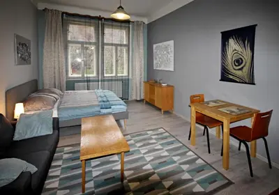 a bedroom with a bed and a table and a couch at Botič Gardenia Residences Prague in Prague