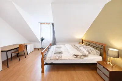 a bedroom with a bed and a desk and a table at Botič Gardenia Residences Prague in Prague