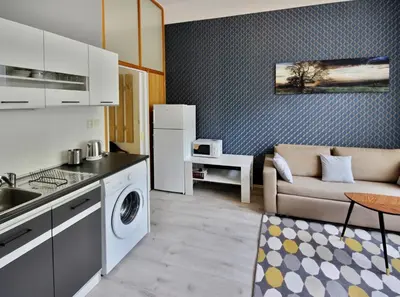 a kitchen and living room with a couch and a table at Botič Gardenia Residences Prague in Prague