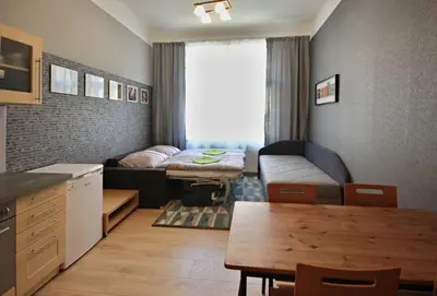 a small living room with a bed and a table at Botič Gardenia Residences Prague in Prague