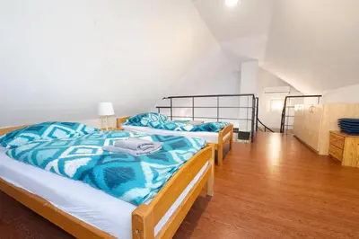 two beds in a large room with wood floors at Botič Gardenia Residences Prague in Prague