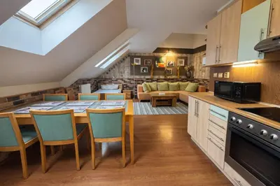 a kitchen and living room with a table and chairs at Botič Gardenia Residences Prague in Prague