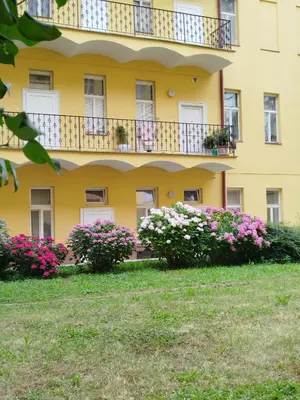 a yellow building with flowers in front of it at Riverside Praha Apartament in Prague