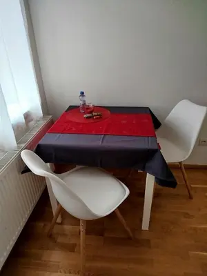 a table with two white chairs and a red table cloth at Riverside Praha Apartament in Prague