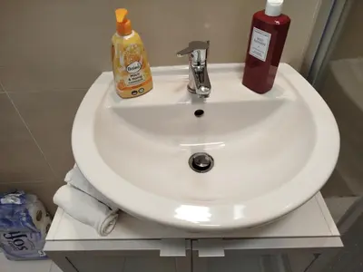 a white sink with a bottle of soap on it at Riverside Praha Apartament in Prague