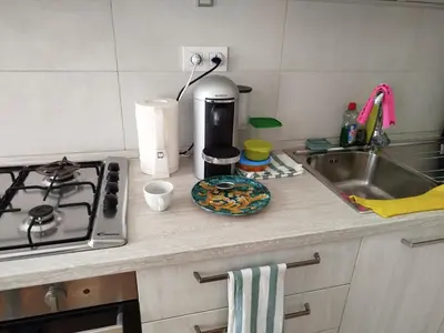a kitchen counter with a stove and a sink at Riverside Praha Apartament in Prague