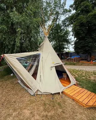 a tent sitting on the grass in a field at Glamping TeePee in Brandýs nad Labem-Stará Boleslav