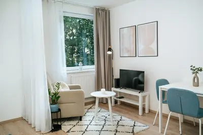 a white living room with a table and a tv at Blue Apartment - Vršovice in Prague
