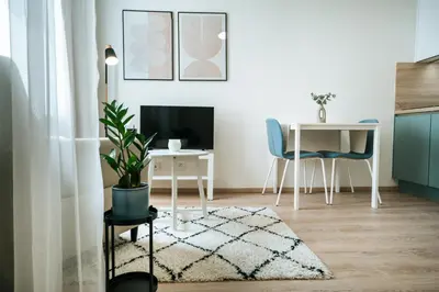 a living room with a desk and a table with a plant at Blue Apartment - Vršovice in Prague