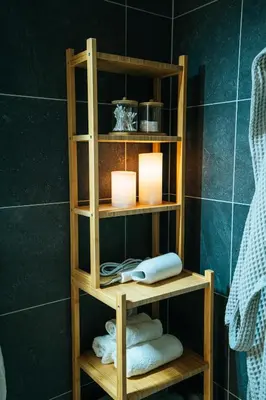 a wooden shelf with two candles and towels in a bathroom at Blue Apartment - Vršovice in Prague