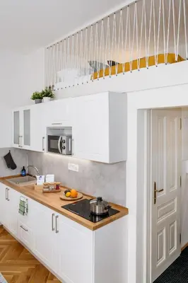 a kitchen with white cabinets and a sink at Prague Days - Fully Equipped Studio near Wenceslas Square in Prague