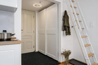 a kitchen with white cabinets and a ladder at Prague Days - Fully Equipped Studio near Wenceslas Square in Prague