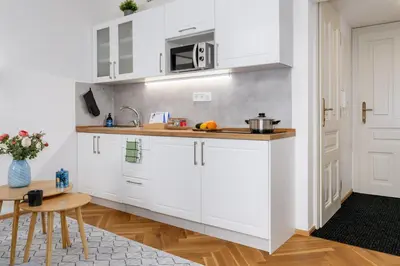 a kitchen with white cabinets and a table at Prague Days - Fully Equipped Studio near Wenceslas Square in Prague