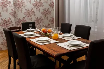 a wooden table with chairs and plates and glasses at Prague Days - Family Friendly Apartment with AC and Netflix in Old Town in Prague