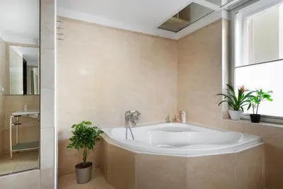 a bathroom with a tub and a window and plants at Prague Days - Family Friendly Apartment with AC and Netflix in Old Town in Prague