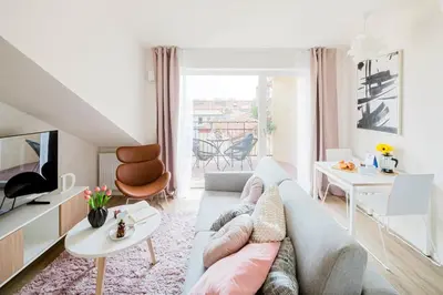 a living room with a couch and a tv at Prague Days - Modern Apartments with AC near King's Park in Prague