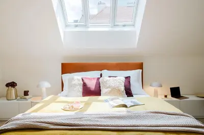 a bedroom with a bed with two books and two lamps at Prague Days - Modern Apartments with AC near King's Park in Prague
