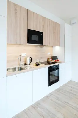 a white kitchen with a sink and a microwave at Prague Days - Modern Apartments with AC near King's Park in Prague