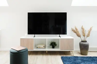a living room with a tv on a white entertainment center at Prague Days - Modern Apartments with AC near King's Park in Prague