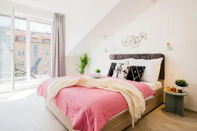 a bedroom with a pink bed and a window at Prague Days - Bright Apartments with AC near Vyšehrad Castle in Prague