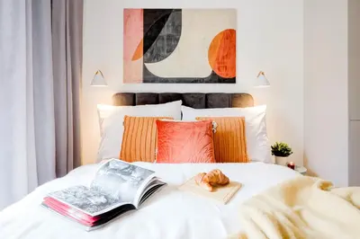 a bedroom with a bed with books and a croissant on it at Prague Days - Bright Apartments with AC near Vyšehrad Castle in Prague
