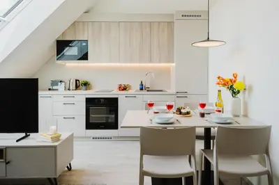 a table with wine glasses and a book on a balcony at Prague Days - Bright Apartments with AC near Vyšehrad Castle in Prague