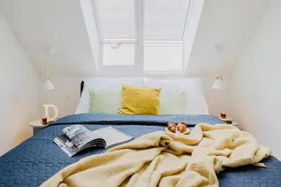 a bedroom with a bed with a blanket and books at Prague Days - Bright Apartments with AC near Vyšehrad Castle in Prague
