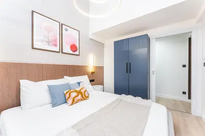 a bedroom with a white bed and a blue door at Rentero Central Loft Apartment in Prague