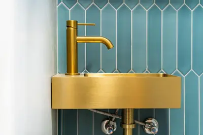 a sink with a gold faucet in a bathroom at Rentero Central Loft Apartment in Prague