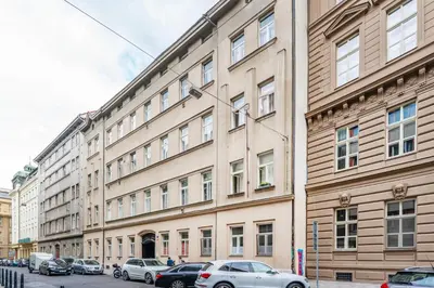 a large building with cars parked in front of it at Rentero Central Loft Apartment in Prague