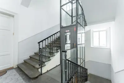 a spiral staircase in a white room with a door at Rentero Central Loft Apartment in Prague