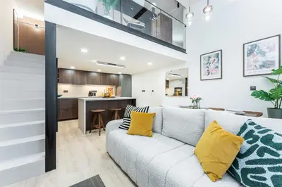 a living room with a couch and a kitchen at Rentero Central Loft Apartment in Prague