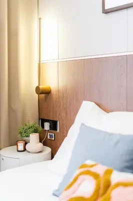 a bedroom with a white bed and a wooden wall at Rentero Central Loft Apartment in Prague