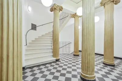 a staircase with columns in a room with a checkered floor at Rhapsody in Prague