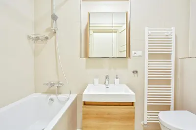 a white bathroom with a sink and a mirror at Rhapsody in Prague