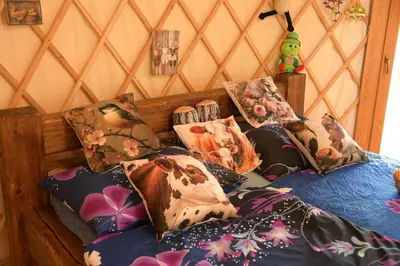 a bed with a bunch of pillows on it at 01 JURTA šedá u stodoly