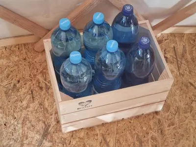 a crate full of water bottles sitting on the floor at 01 JURTA šedá u stodoly