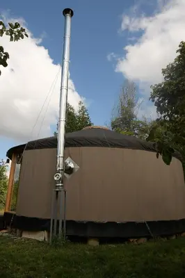 a tent with a pole in the grass at 02 JURTA hnědá v jablečném sadu