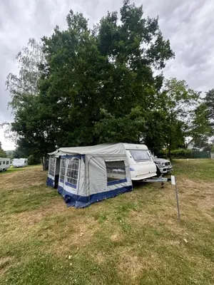 a tent and a car parked in a field at Karavan Ždáň in Slapy