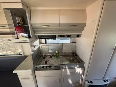 a kitchen with a sink and a stove in an rv at Karavan Ždáň in Slapy