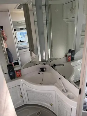 a bathroom with a sink and mirrors in an rv at Karavan Ždáň in Slapy