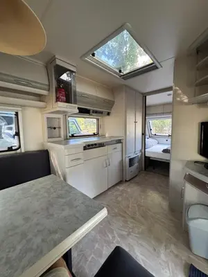 an rv kitchen with a table and a window at Karavan Ždáň in Slapy