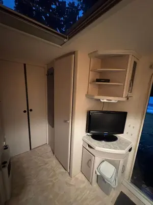 a small room with a tv on a table in an rv at Karavan Ždáň in Slapy