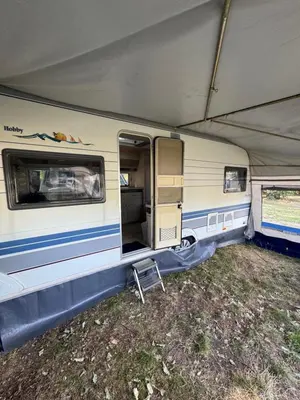 an old caravan with its door open in a field at Karavan Ždáň in Slapy