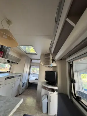 an rv with a kitchen and a tv in it at Karavan Ždáň in Slapy