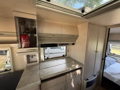a small kitchen in an rv with a bed at Karavan Ždáň in Slapy