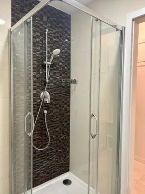 a shower with a glass door in a bathroom at Cozy Budget Studio by F&S in Prague